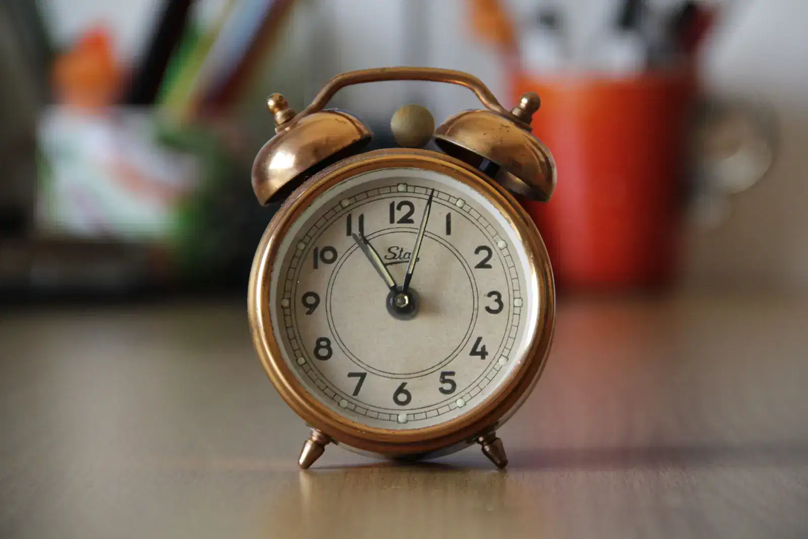 A copper alarm clock on a wooden table, an image of a false alarm in the nervous system: what causes panic attacks, why panic attacks occur, and why a panic attack can seem to come out of the blue, with a rush of adrenaline and fear.
