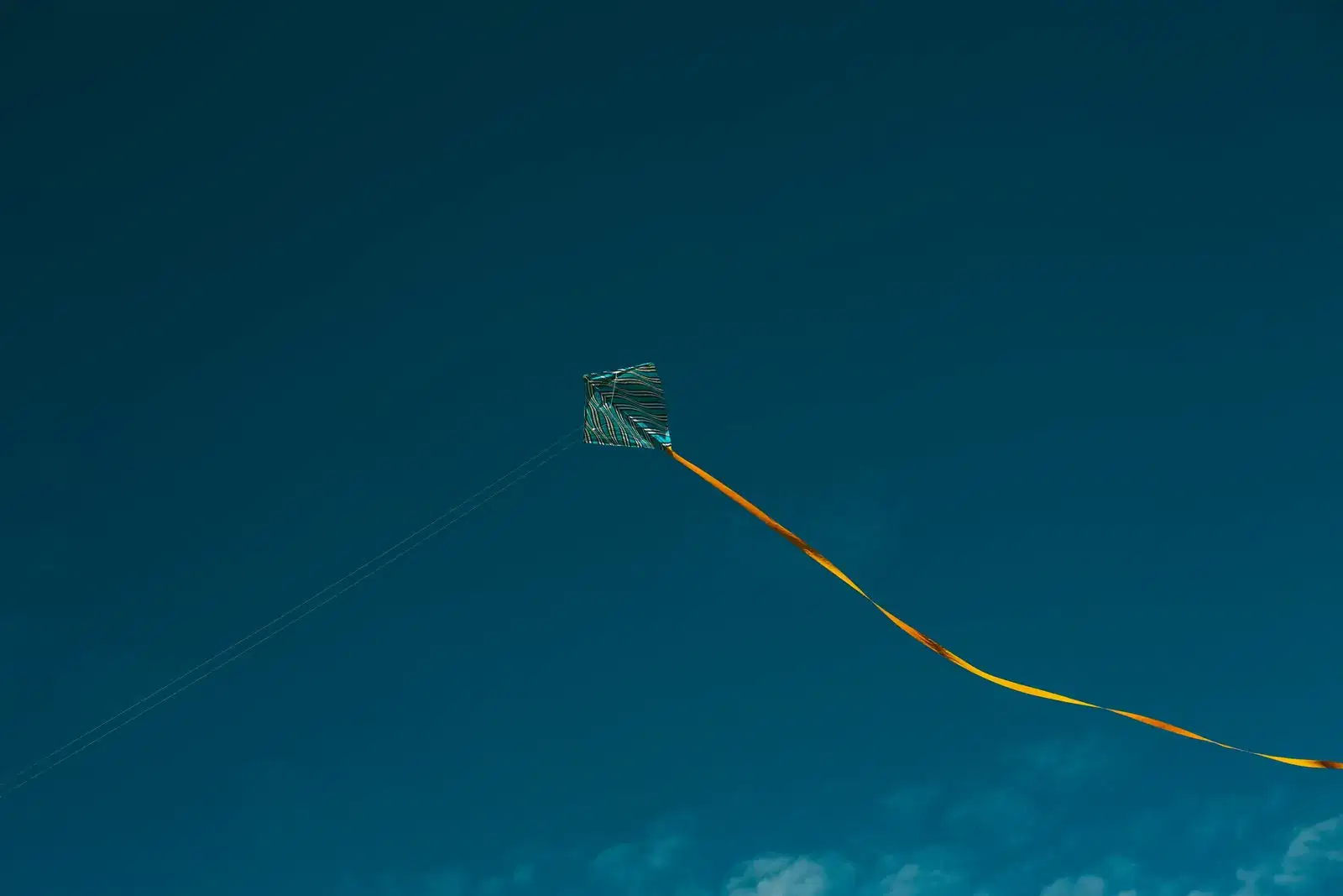 A kite holding steady against a teal sky, a picture of coping strategies, healthy habits and support when you want to manage anxiety