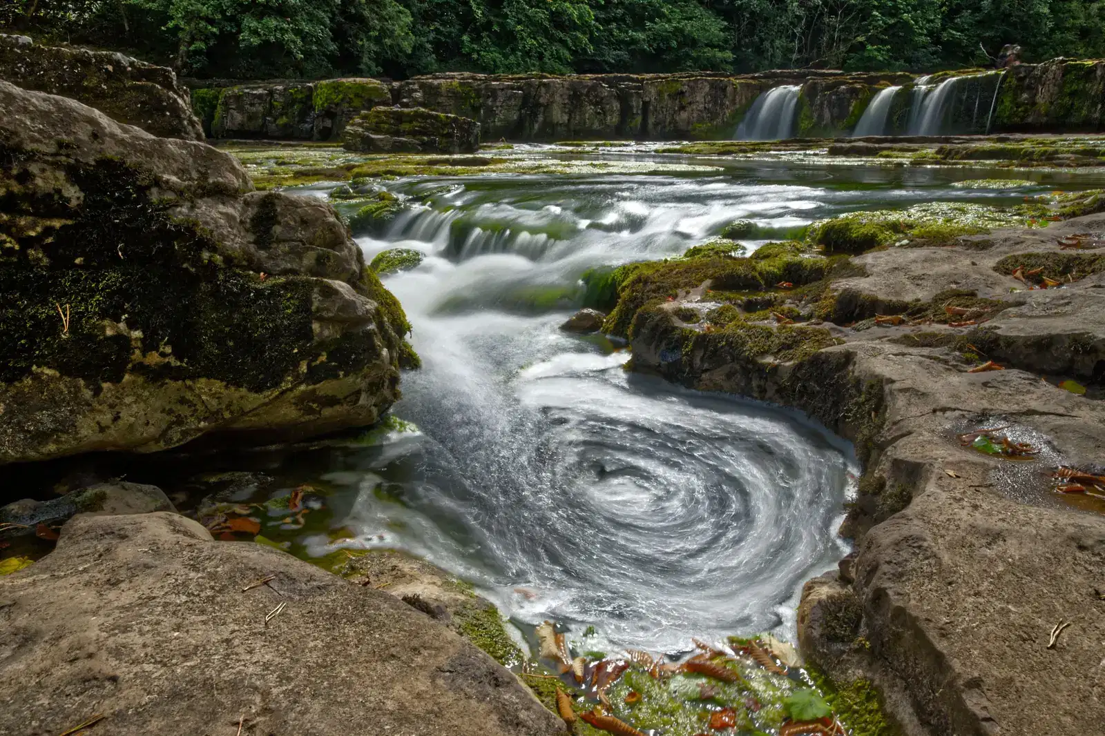 Water swirling in a rocky stream pool, like the cycle that keeps gamblers chasing losses and makes it so hard to quit or stop gambling.