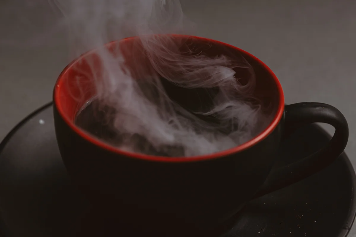 Steam rising from a dark mug, a moment to slow down and breathe