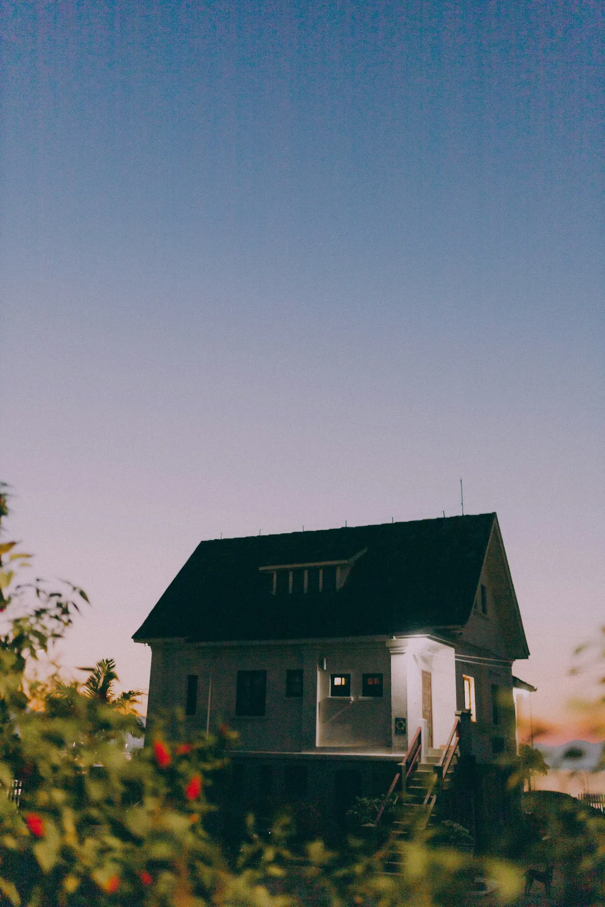 A small house with warm, lit windows at dusk, a picture of friendship and trust as foundations